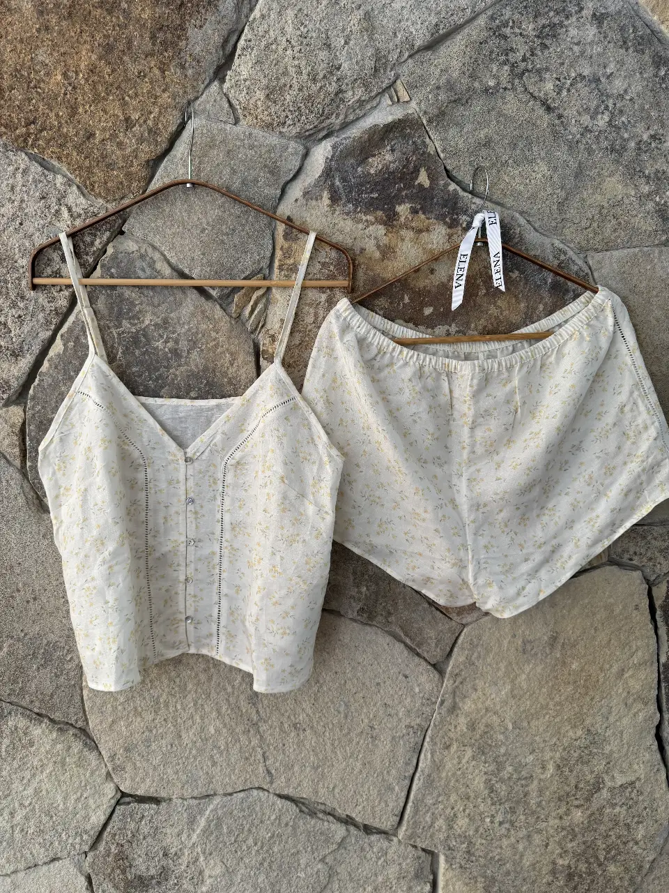 Conjunto de pijama de dos piezas, ideal para el verano. Incluye un top con botones y tirantes finos, y un short con cintura elastizada. Confeccionado en tela liviana con estampado floral.