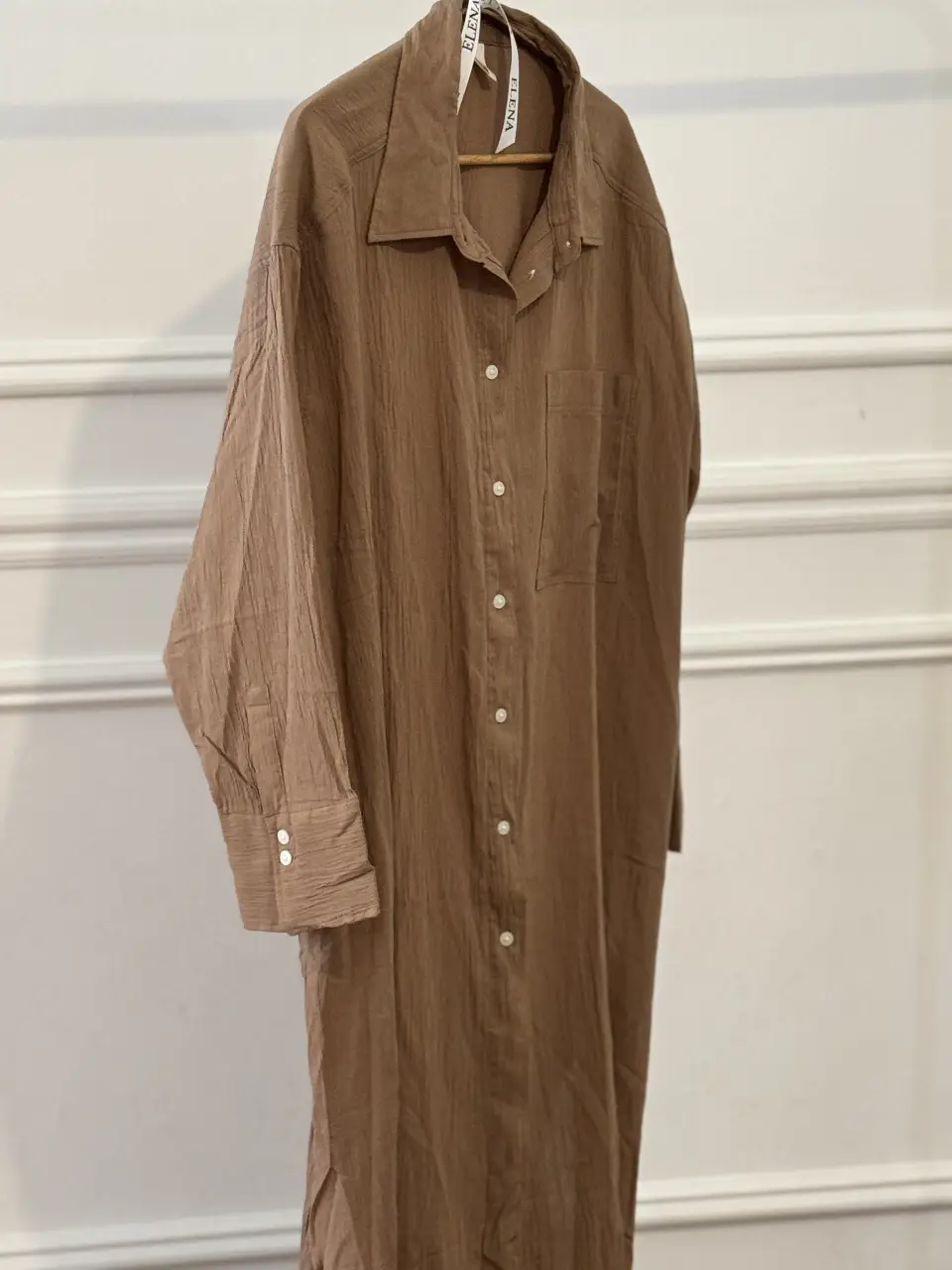 Camisa larga de mujer en color marrón, con botones y bolsillo. Ideal para un look casual y cómodo.