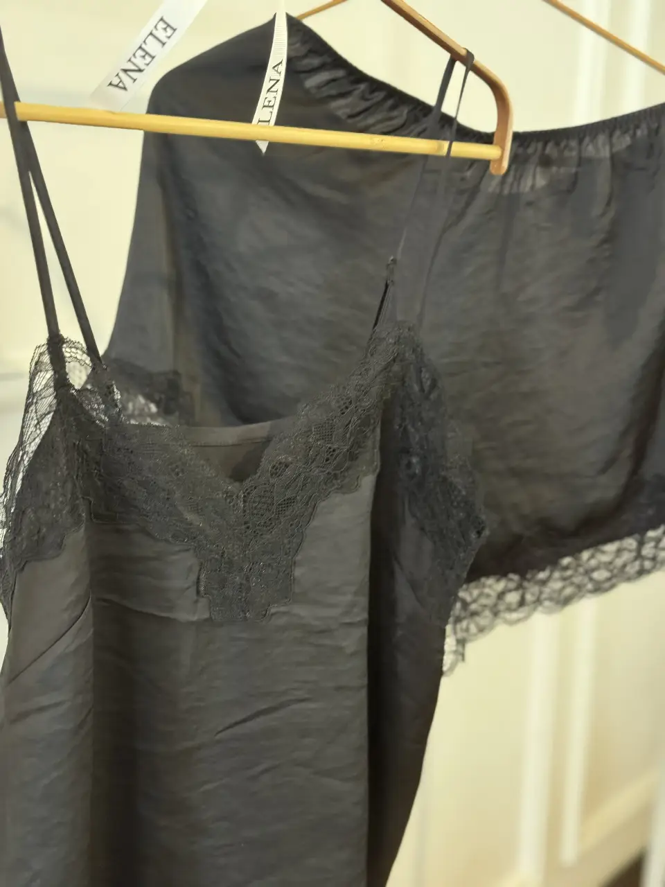Conjunto de lencería de satén negro con detalles de encaje. Incluye un top con tirantes finos y un short con cintura elástica y encaje en el borde. Ideal para una noche especial o para sentirte cómoda y elegante en casa.