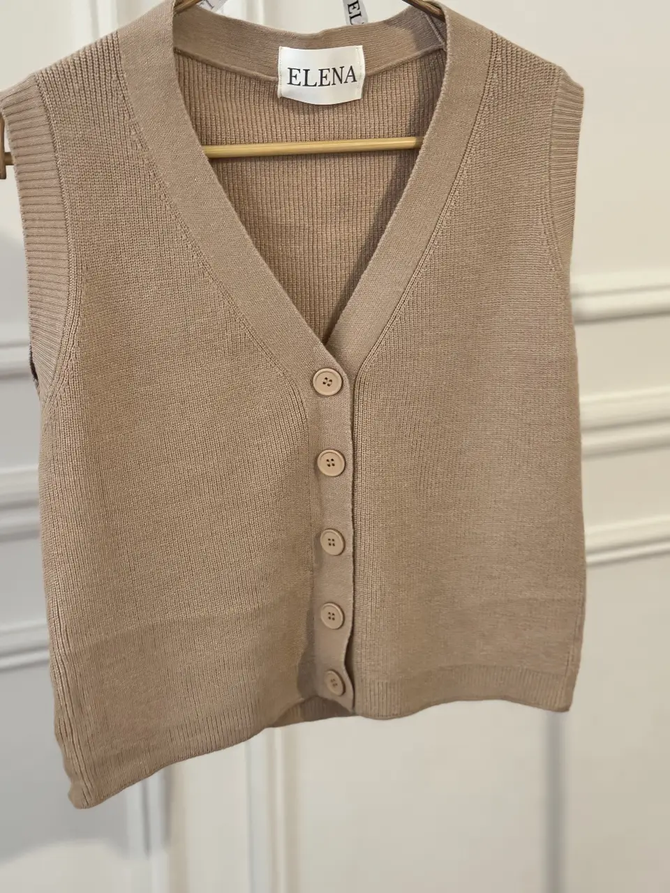Chaleco tejido de punto, con cuello en V y botones. Ideal para un look casual y moderno. Perfecto para combinar con camisas o remeras.