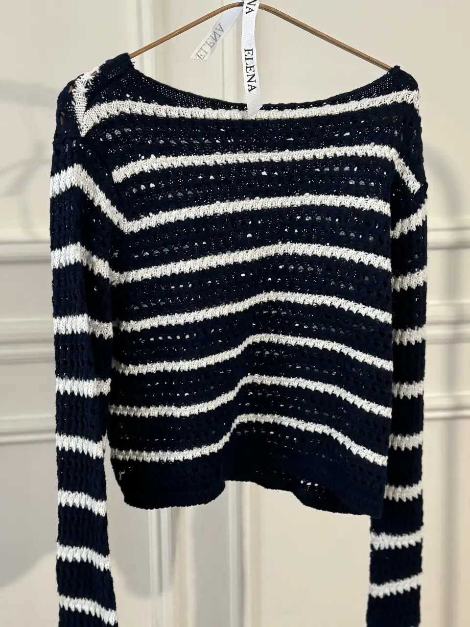 Sweater de punto a rayas horizontales en color azul marino y blanco. Diseño de manga larga y cuello redondo. Ideal para un look casual y cómodo.