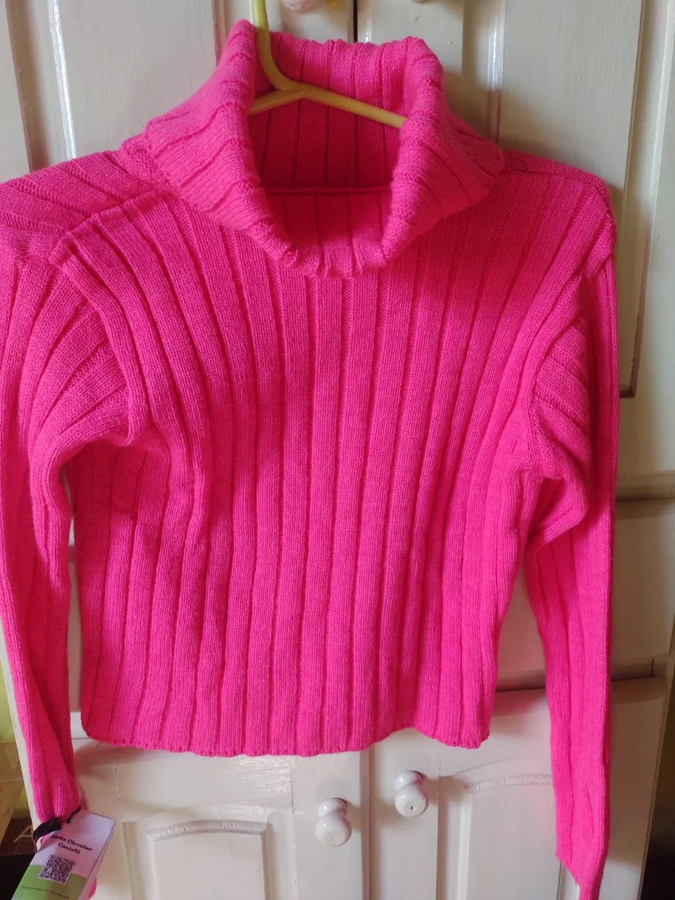 Sweater de mujer color rosa chicle, con cuello alto y tejido acanalado. Ideal para un look moderno y abrigado.