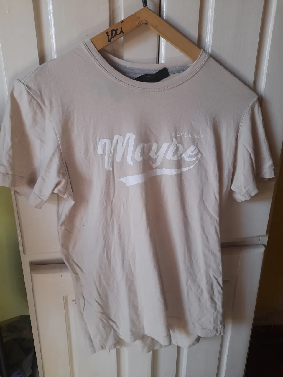 Remera de hombre color crudo con estampado "Maybe" en blanco. Corte clásico, ideal para un look casual y relajado. Perfecta para combinar con jeans o shorts.