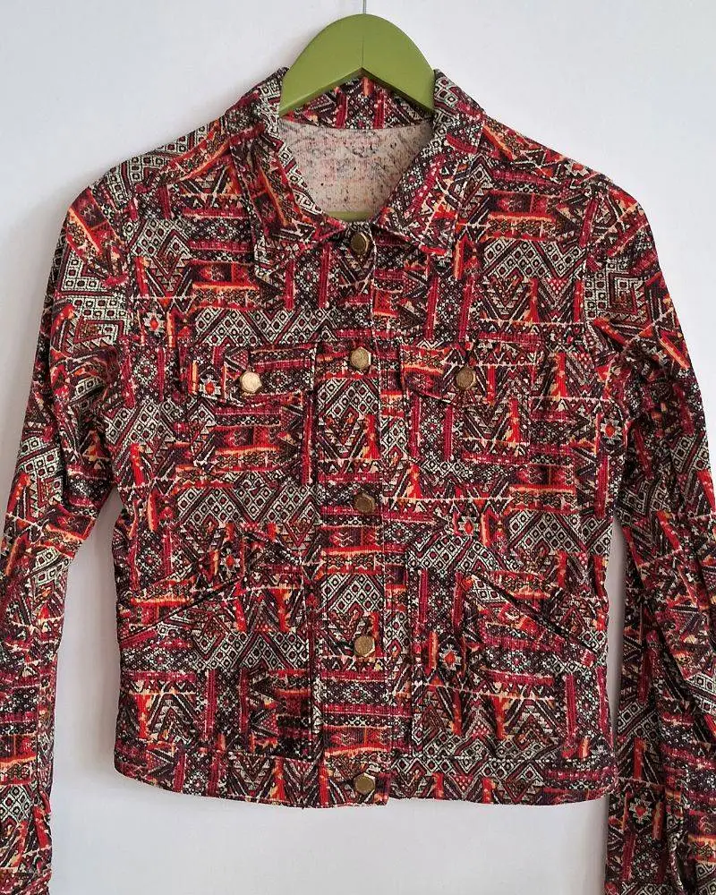 Campera Rapsodia de tela tipo corderoy estampada y aplique de tachitas en espalda. Posee cuatro pequeños bolsillos. Buen estado. Talle XS. Medidas aproximadas: hombros 38cm, pecho 40cm, largo 50cm.