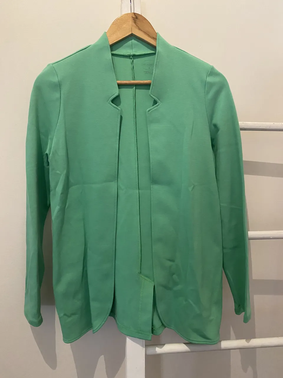 Blazer verde menta sin botones, con cuello mao y tajos laterales. Ideal para un look canchero y moderno.