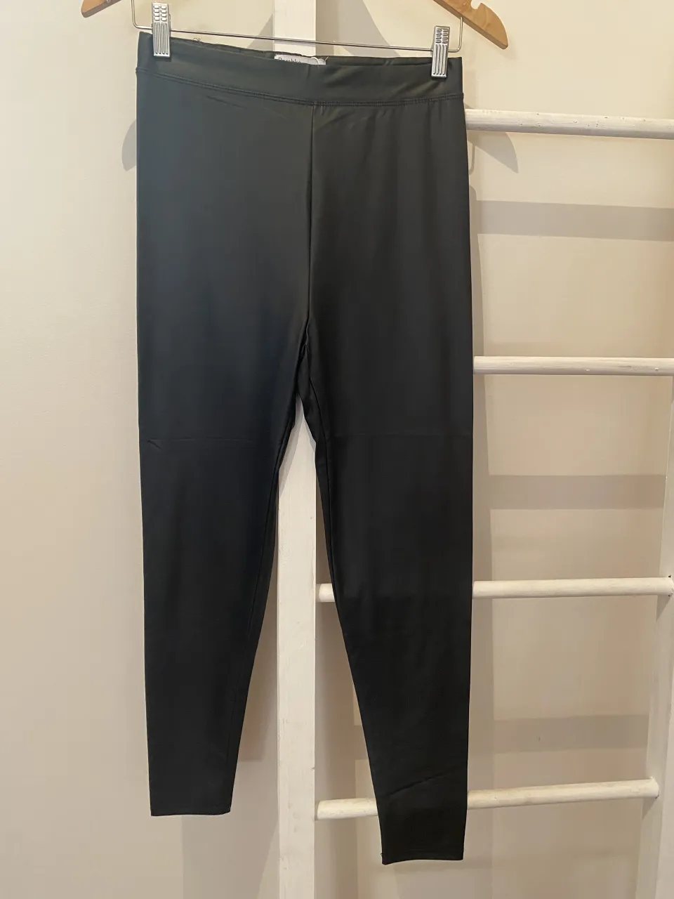 Calza negra tiro alto, ideal para entrenar o para un look comfy. Su corte al tobillo la hace súper versátil.