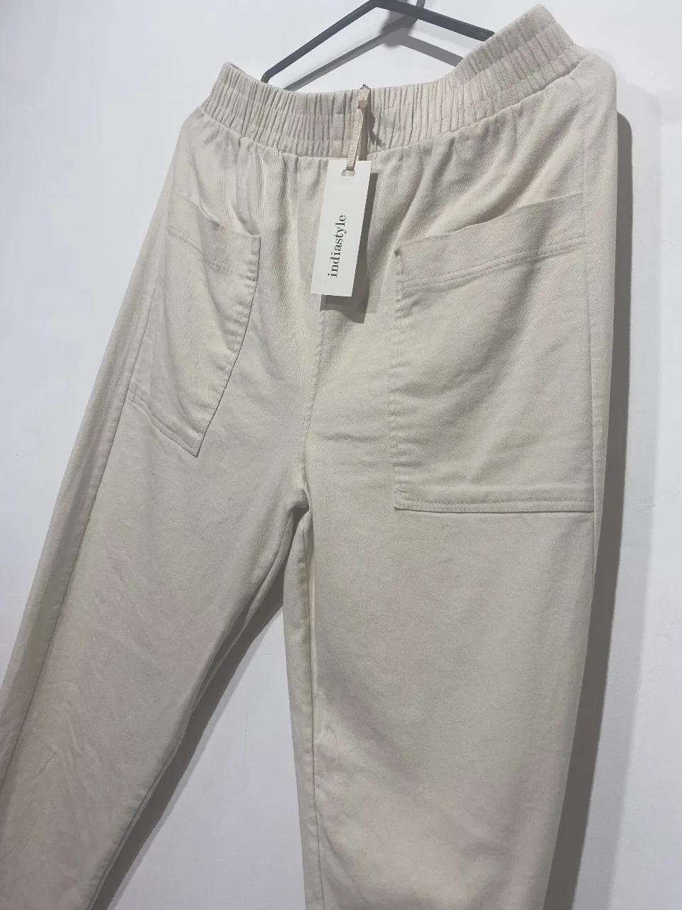 Pantalón de gabardina color crudo, tiro alto con cintura elastizada y cordón. Posee bolsillos amplios en los laterales y en la parte trasera. Un básico súper cómodo y versátil para tu día a día.