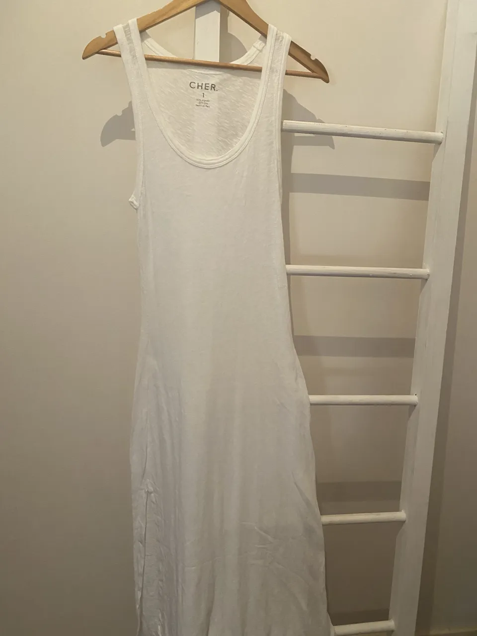 Vestido blanco largo de algodón, estilo musculosa. Posee tajos laterales para mayor comodidad y movimiento. Ideal para un look casual de verano o para usar en la playa.