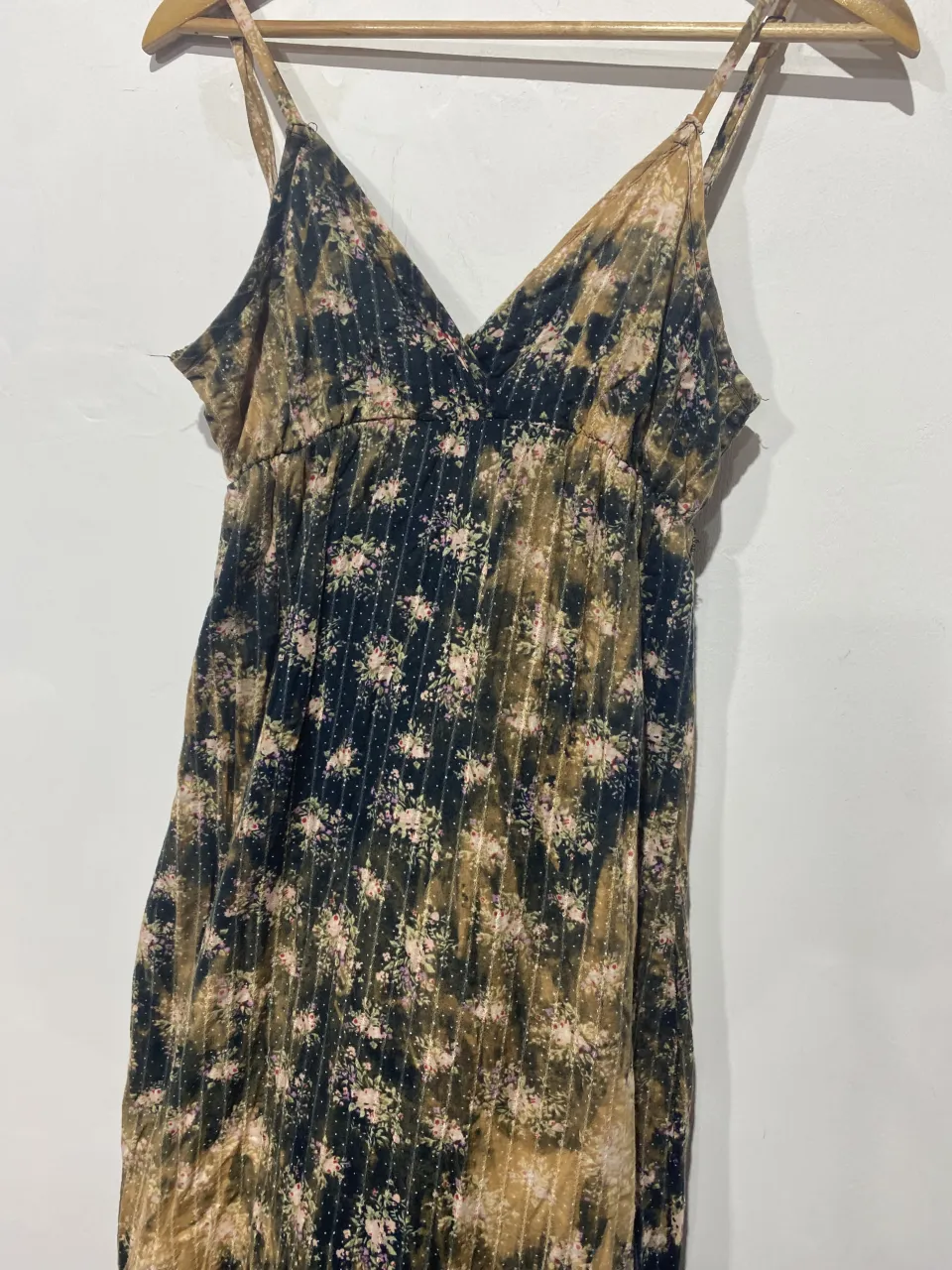 Vestido largo estampado floral con tiras finas y escote en V. Posee un elástico en la cintura que le da un calce canchero y cómodo. Ideal para un look relajado y femenino.