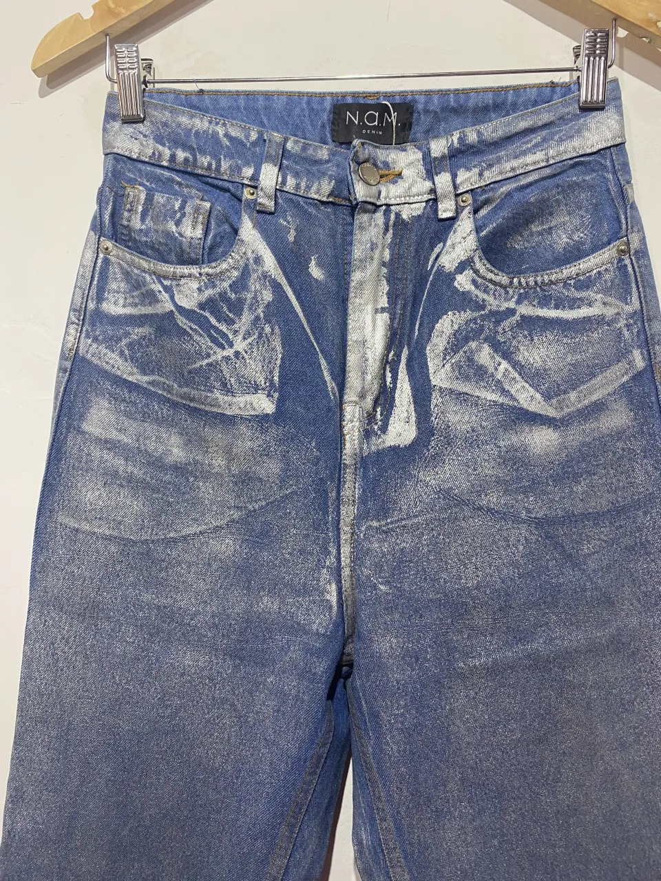 Jeans tiro alto con lavado plateado y detalles desgastados. Un diseño único y moderno para destacar tu estilo.