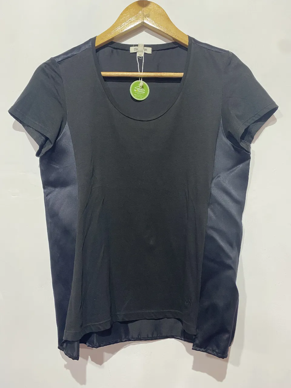 Remera negra de manga corta con detalles de seda en los laterales. Un básico elegante y moderno, ideal para elevar cualquier look.