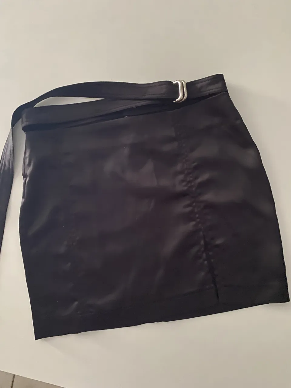 Pollera negra corta con cinto y tajito. Ideal para looks cancheros y para salir.