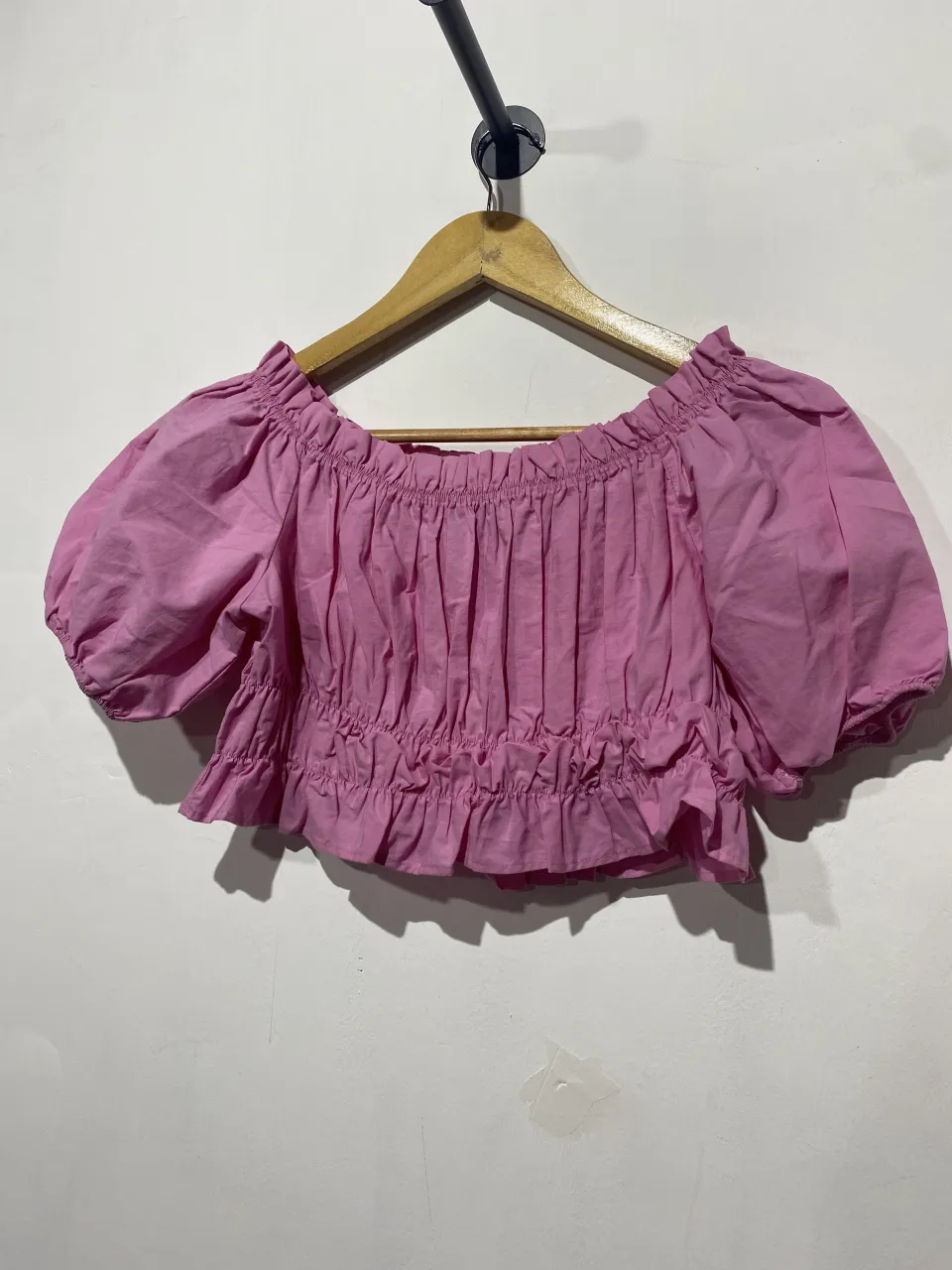 Top rosa strapless con fruncido y volados. Posee mangas cortas abullonadas y elástico en el borde superior y en la cintura. Ideal para un look canchero y fresco.