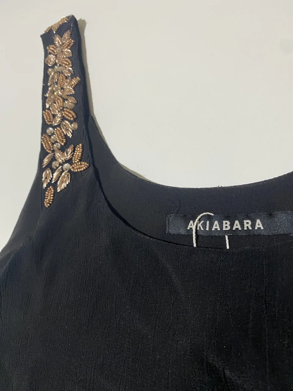 Top negro con detalles bordados en los breteles. Ideal para un look canchero y elegante.