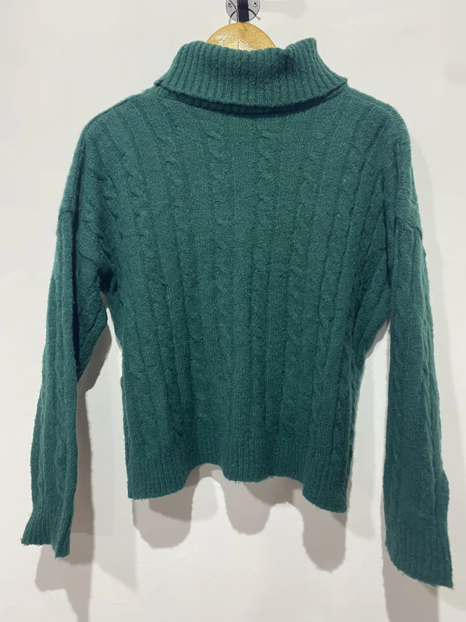 Sweater de lana tejido con trenzas y cuello alto. Ideal para los días fríos de otoño e invierno, perfecto para un look casual y cómodo.