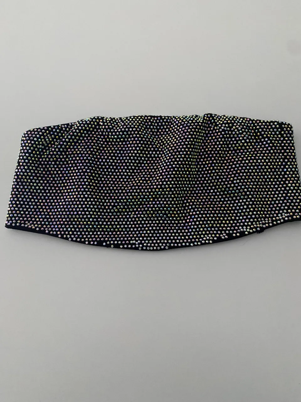 Top strapless negro con apliques de strass multicolor en toda la prenda. Posee cordones para atar en la espalda.