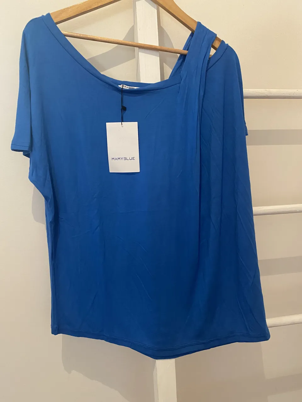 Remera azul de MamyBlue con un diseño asimétrico y escote Bardot. Ideal para un look casual y moderno.
