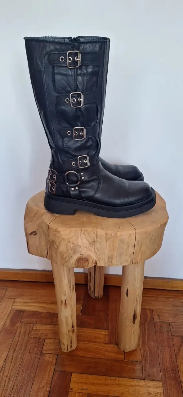 Botas de caña alta negras con hebillas y cierre lateral. Estilo rocker, ideales para un look audaz.