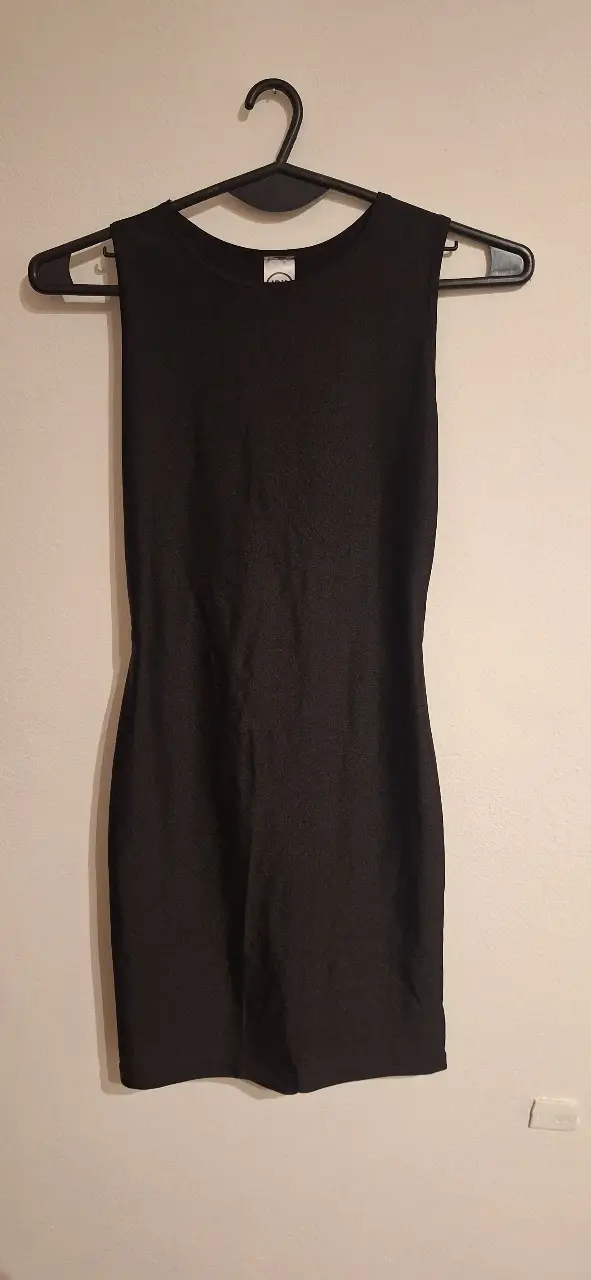 Vestido negro mini, sin mangas, con espalda descubierta y corte ajustado. Ideal para salidas y fiestas.
