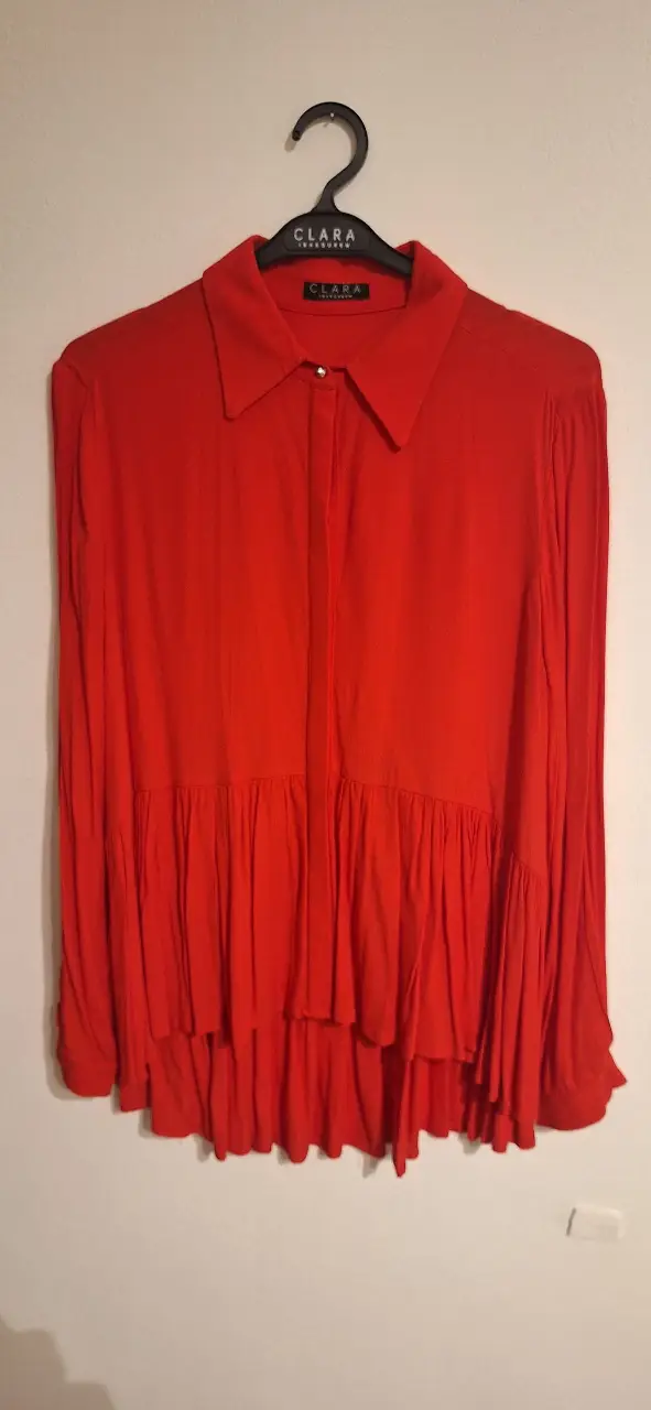 Blusa roja de manga larga con detalle de volados en la parte inferior. Talle 38, de la marca Clara Ibarguren. 