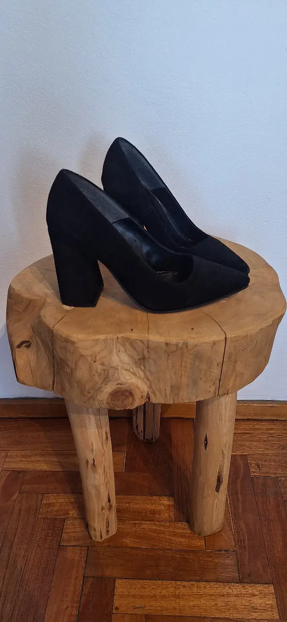 Elegantes tacos negros de cuero gamuzado con taco ancho. Ideales para fiestas y eventos formales.