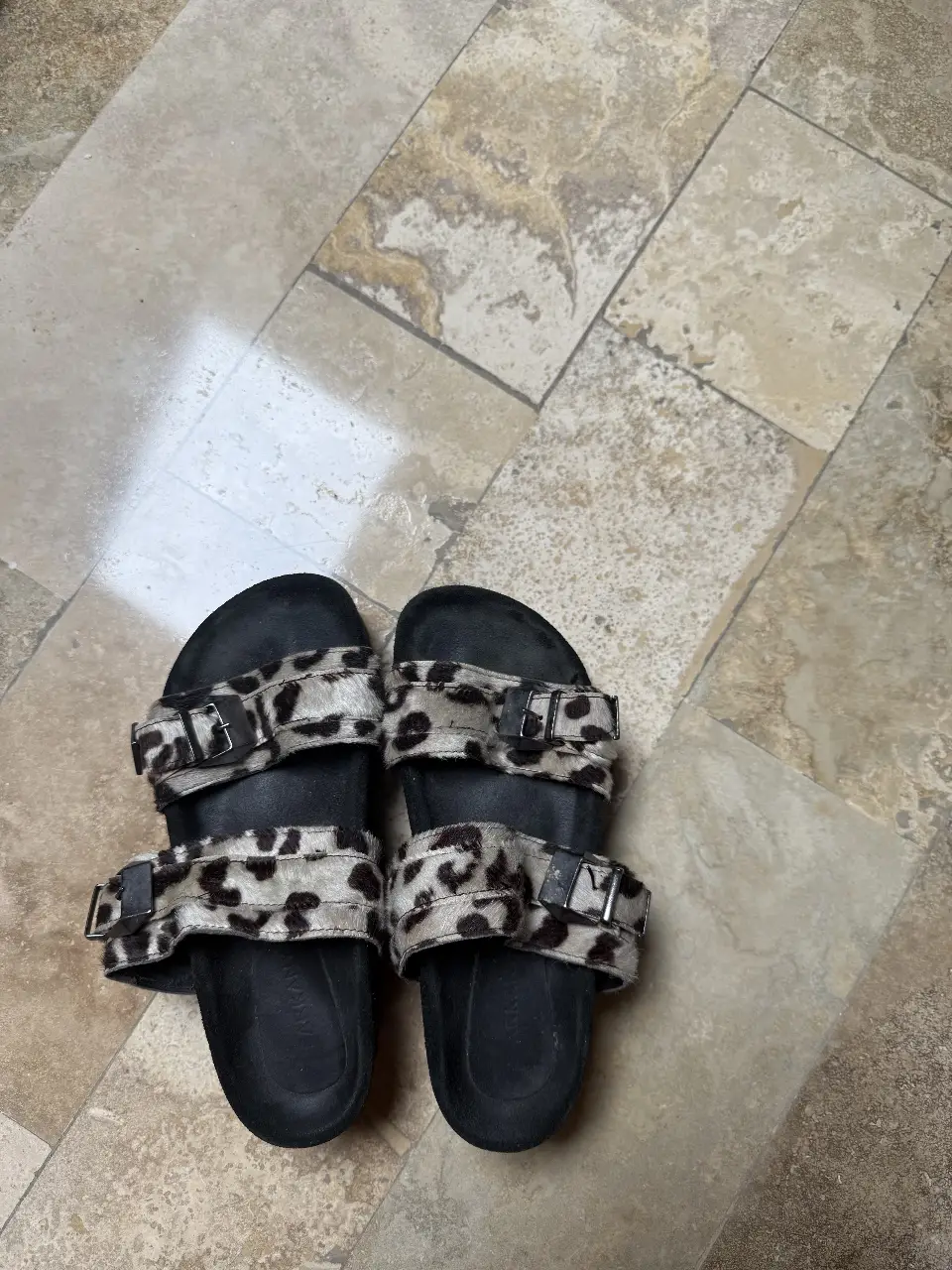 Sandalias de mujer con diseño de leopardo en la capellada y hebillas metálicas. Base negra con suela de goma.