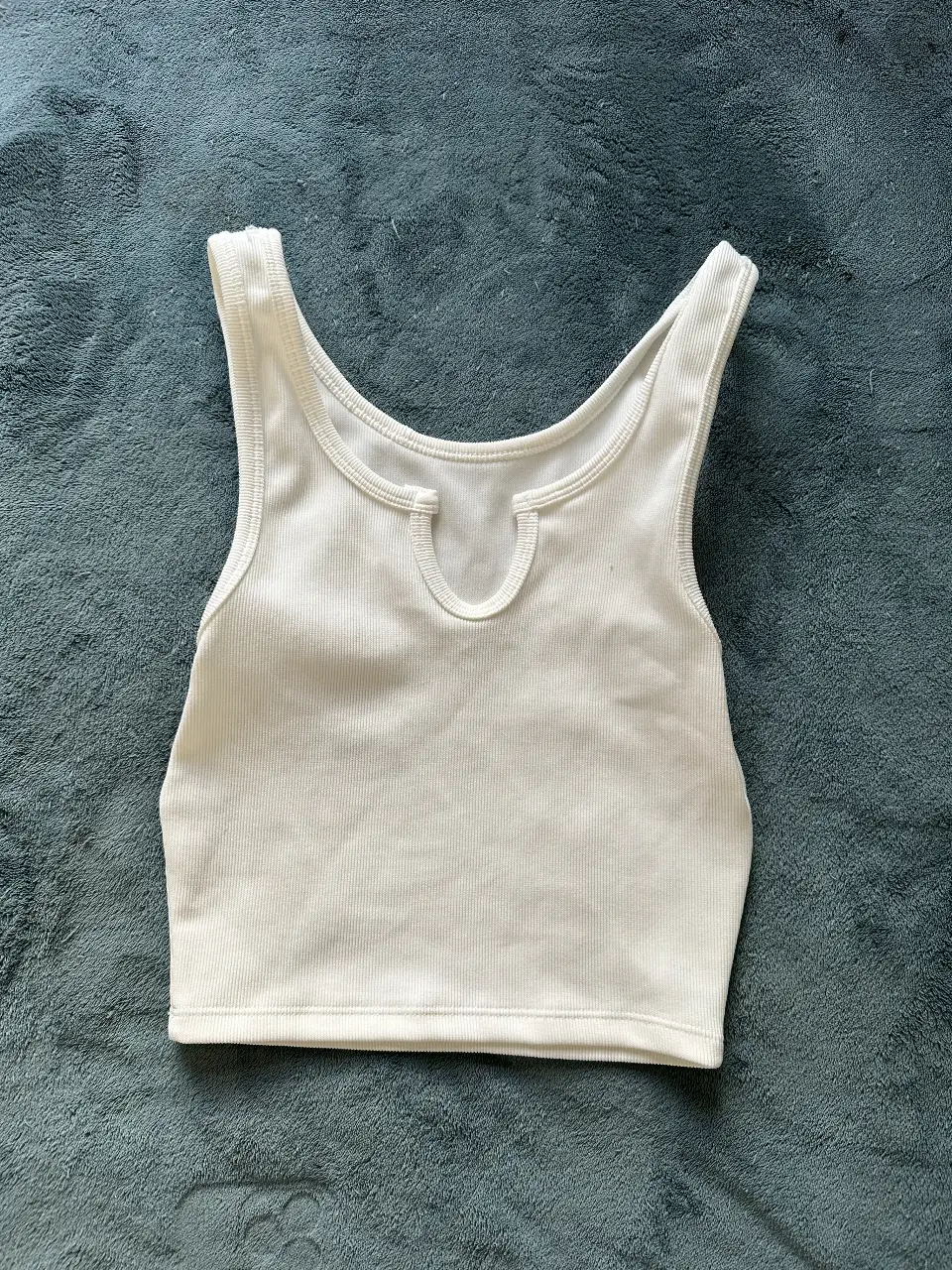 SIN USO. Top blanco de algodón con escote redondo y detalle de abertura. Ideal para un look casual y fresco.