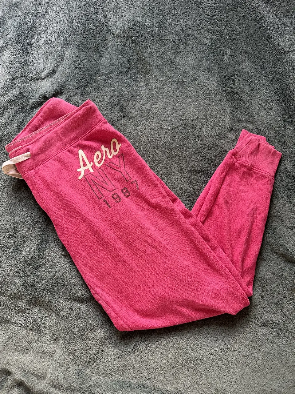 Pantalón de jogging rosa de la marca Aeropostale, con el logo estampado en la pierna. Ideal para un look casual y cómodo.