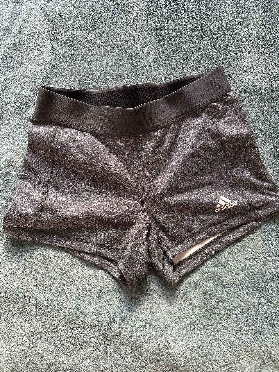 Short deportivo Original Adidas gris, ideal para entrenamientos. Confeccionado con tejido técnico que absorbe la humedad y logo de la marca en blanco. SIN USO 