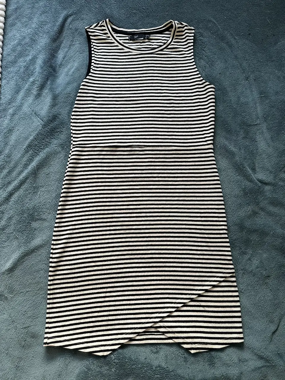 Vestido importado sin uso, mini a rayas horizontales en blanco y negro, sin mangas y con un diseño asimétrico en la parte inferior. Ideal para un look casual y moderno.