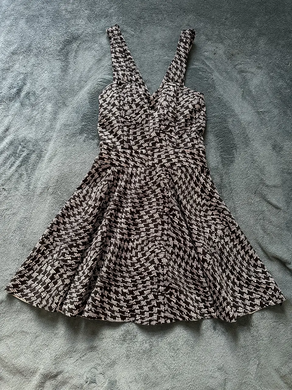Vestido importado mini con estampado geométrico en blanco y negro. Diseño con escote en V y tirantes anchos. Ideal para una salida o evento especial.