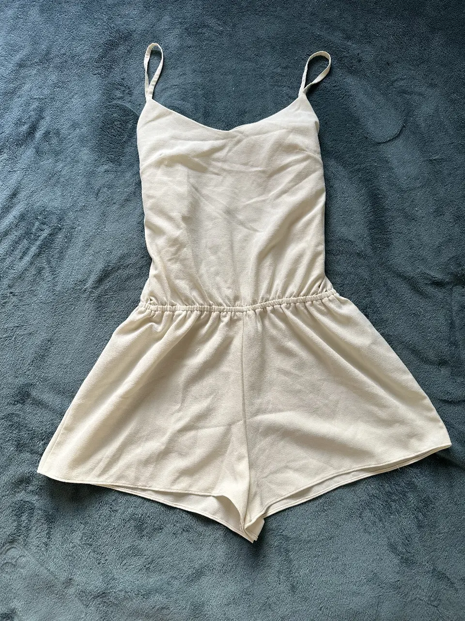 Mono corto de mujer, color blanco, con tirantes finos y cintura elastizada. Ideal para el verano, cómodo y fresco.