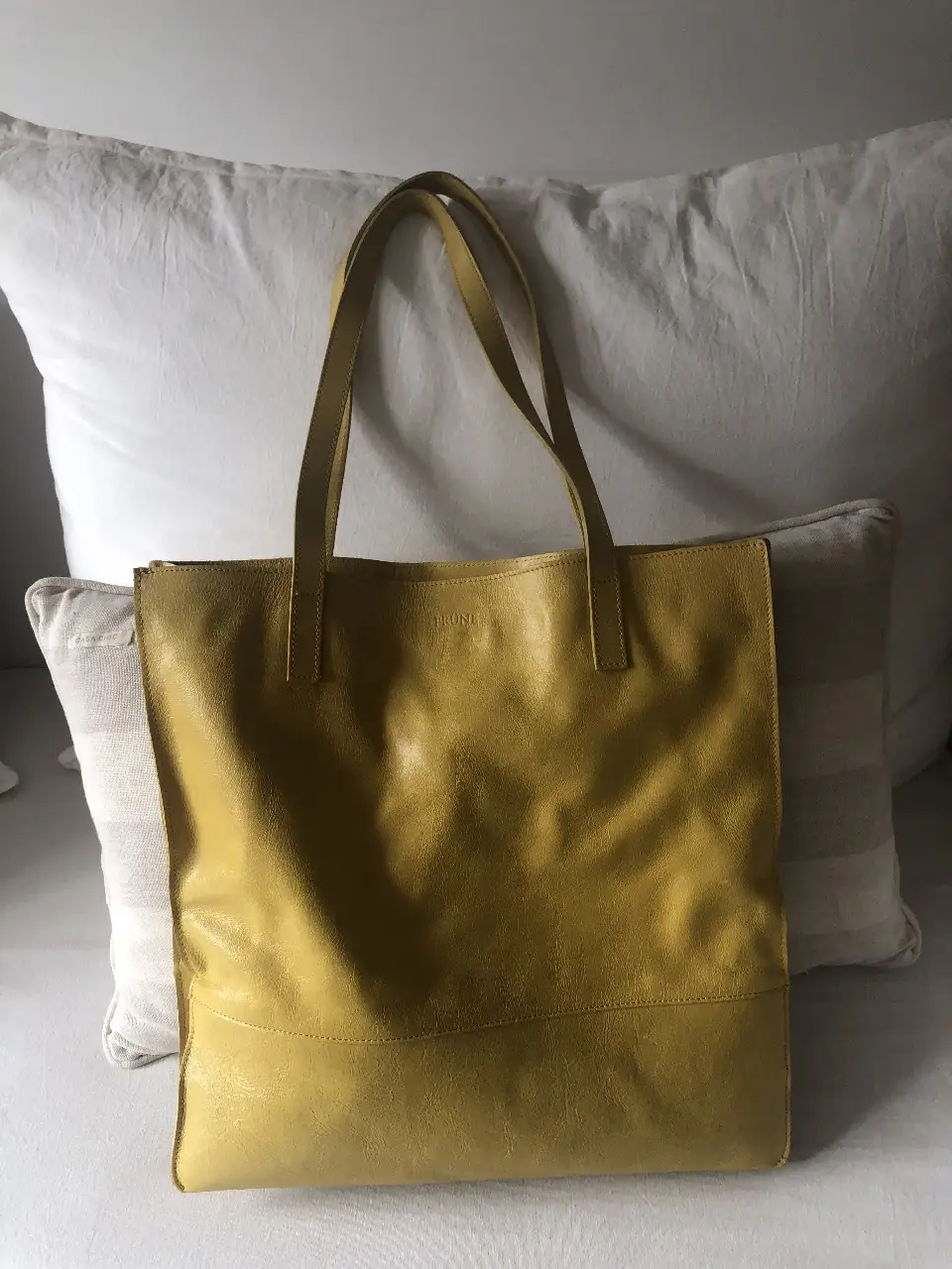 Bolso tote de cuero amarillo, ideal para llevar todo lo necesario con estilo. Perfecto para el día a día.
