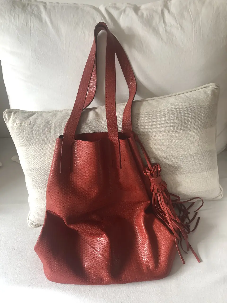 Cartera tote bag roja con textura de cuero, ideal para llevar todo lo que necesitas con estilo. Perfecta para un look casual y moderno.