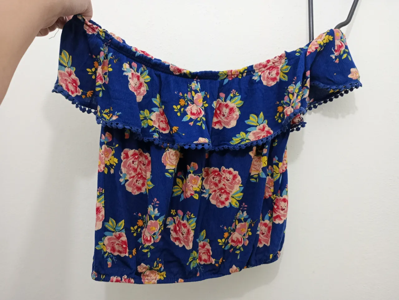 Top floral azul con hombros descubiertos y volado. Detalle de pompones en el borde. Ideal para un look fresco y playero. la tela es como una válvula muy delicada y suave