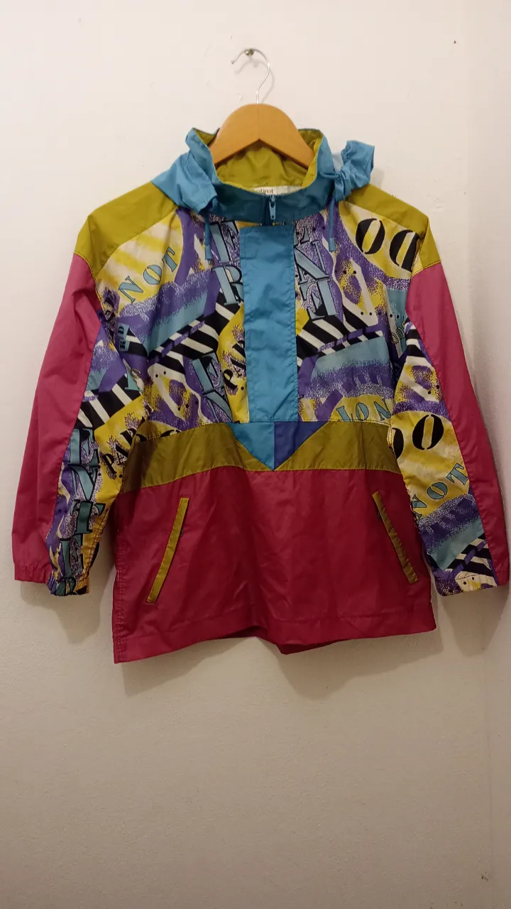 Campera anorak súper colorida y original, con un diseño retro y vibrante. Ideal para darle un toque único a tus looks. Posee capucha y bolsillos frontales con cierre. piloto,la caucha se puede guardar 