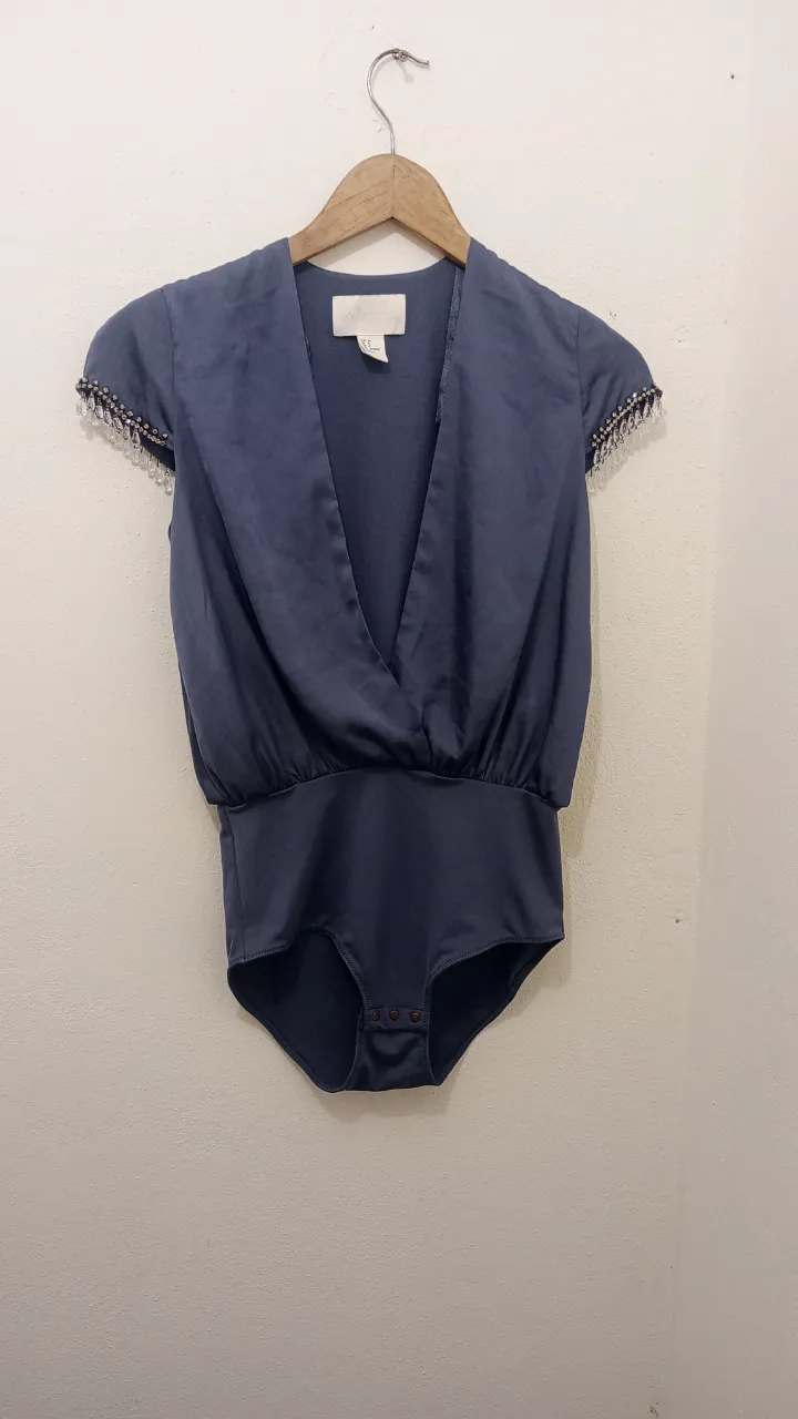 Body con detalles de strass y canutillos en las mangas. Escote en V cruzado y cintura elastizada. Ideal para una salida elegante o una fiesta. La parte de la cintura para abajo es elastizada efecto faja muuuy linda queda