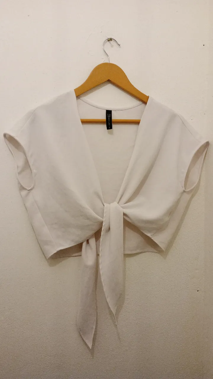 Top blanco de seda tipo creep, con nudo delantero y mangas cortas. Ideal para un look elegante y fresco.Marca MATERIA 
abarca hasta un talle L y para M puede ir muy bien también 