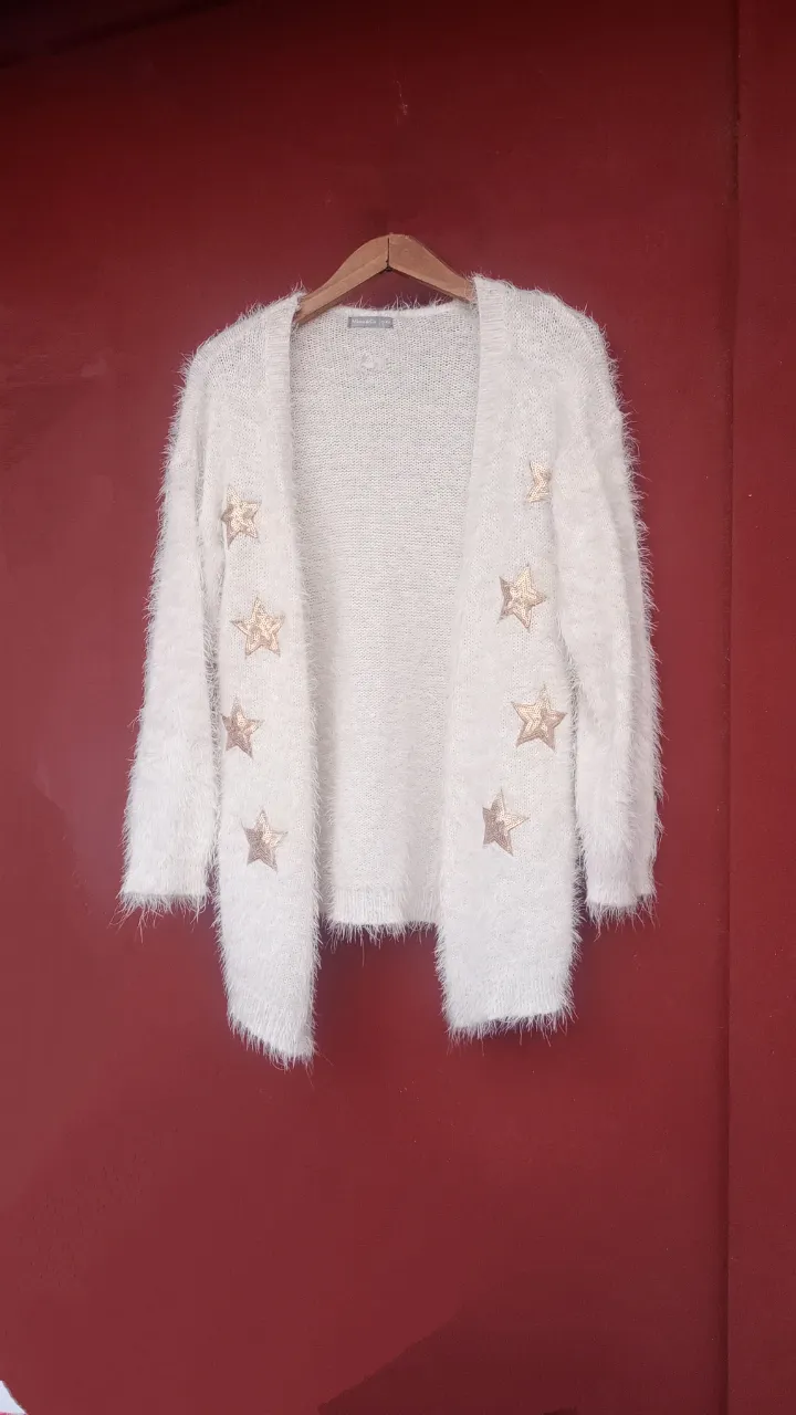 Cardigan blanco de tejido suave con estrellas doradas bordadas. Manga larga y escote en V.