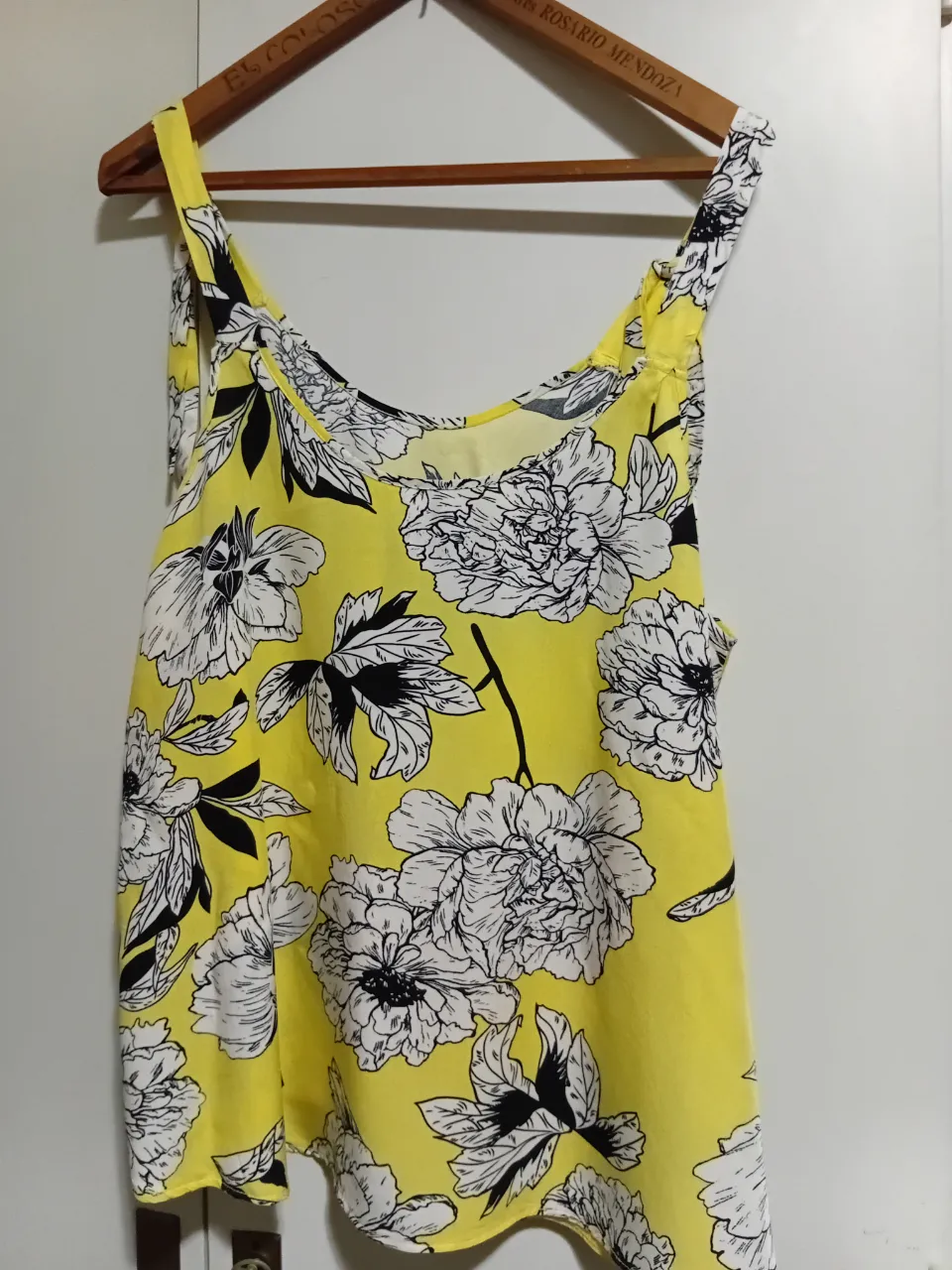 Musculosa amarilla con estampa floral en blanco y negro. Ideal para un look fresco y canchero.