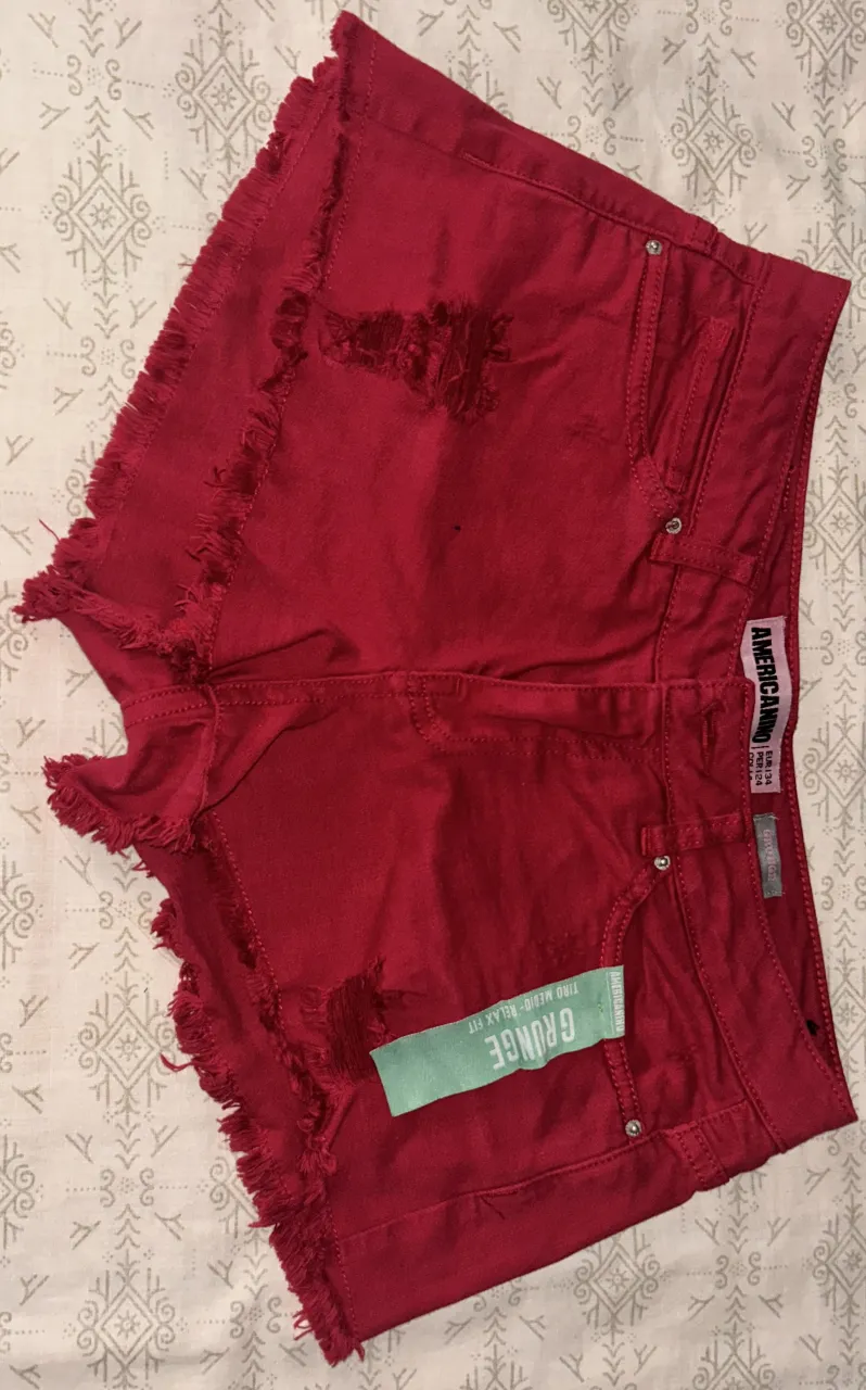 Shorts de jean tono bordó con roturas y detalles deshilachados en los bordes. Tiro medio. 4 bolsillos. Sin uso.
