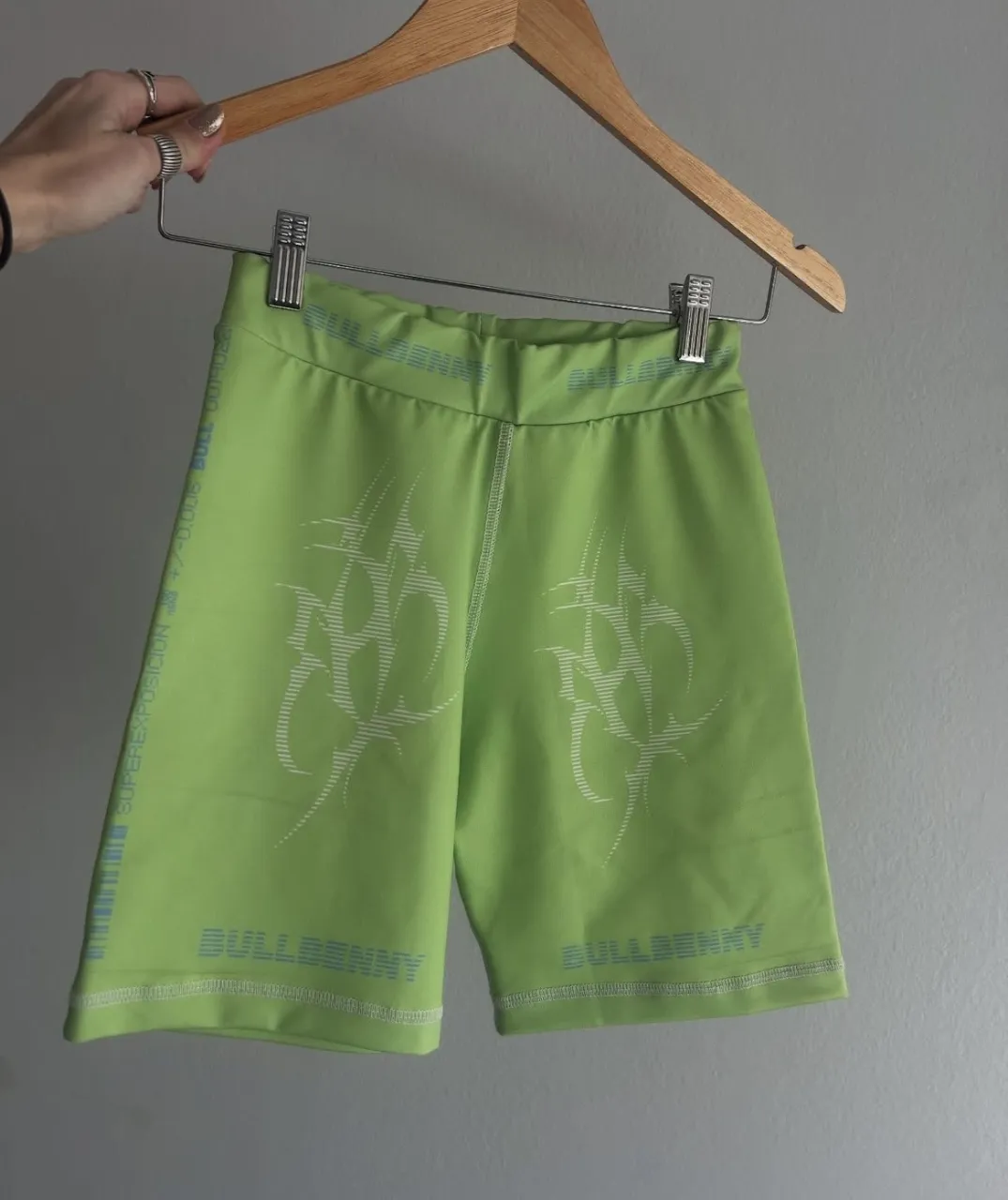 Shorts de ciclista color verde lima con estampa blanca y detalles en azul. Posee inscripción "BULLBENNY" en la cintura y en los laterales.