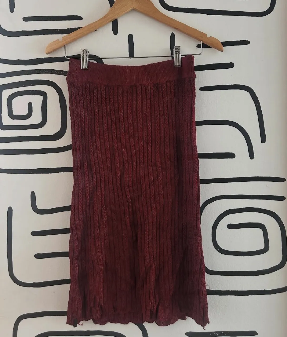 Pollera de tejido de punto color bordó. Posee detalle de terminación en el ruedo.