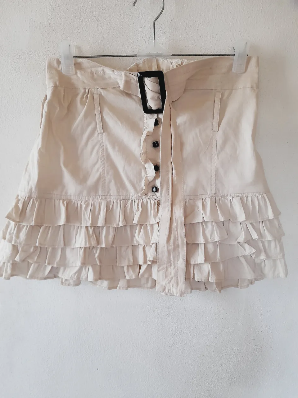 Conjunto intervenido de Camisa crop y pollera folk  beige con volados, cinturón con hebilla negra y botones frontales. Ideal para looks de día o para el verano. ¡Súper canchera y fresca!    Pollera: cintura:34cm.  Largo:39cm.    Camisa:axila a axila:40cm.   