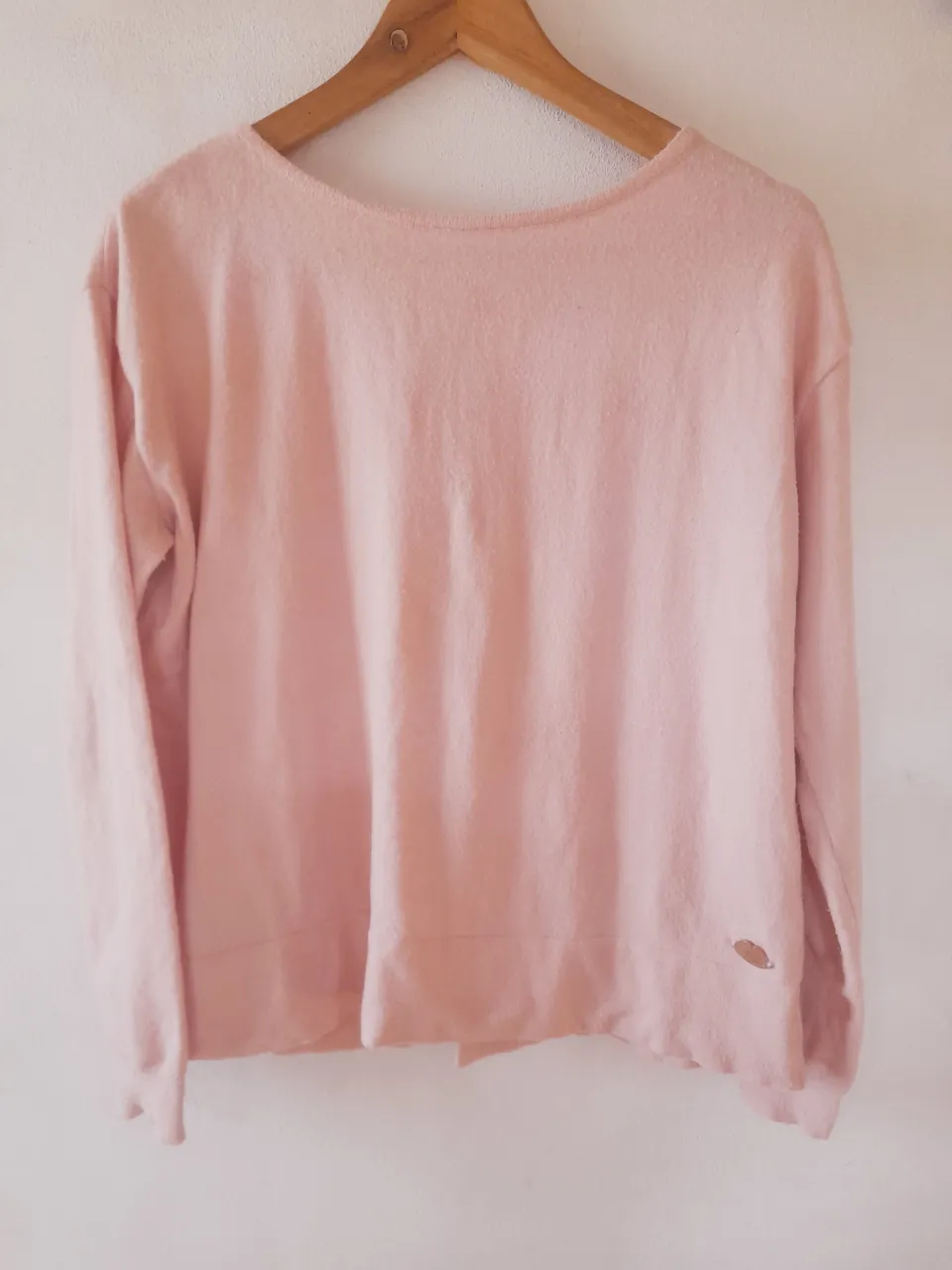 Sweater rosa bebé Millie re dulce y femenino. Con un detalle divino de lazos en la espalda que lo hacen único. Cuello redondo y manga larga, ideal para media estación o esos días frescos. Tiene algo de peeling por el material.    Largo:56cm.   Axila a axila:56cm. 