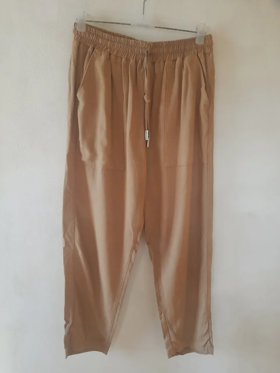 Pantalón de lino marca Millie en color camel. Con cintura elástica y lazo ajustable, bolsillos laterales y una tela súper cómoda. ¡Ideal para un look relajado y con onda!   Cintura:32/47cm.    Cadera:56cm.    Tiro:35cm.