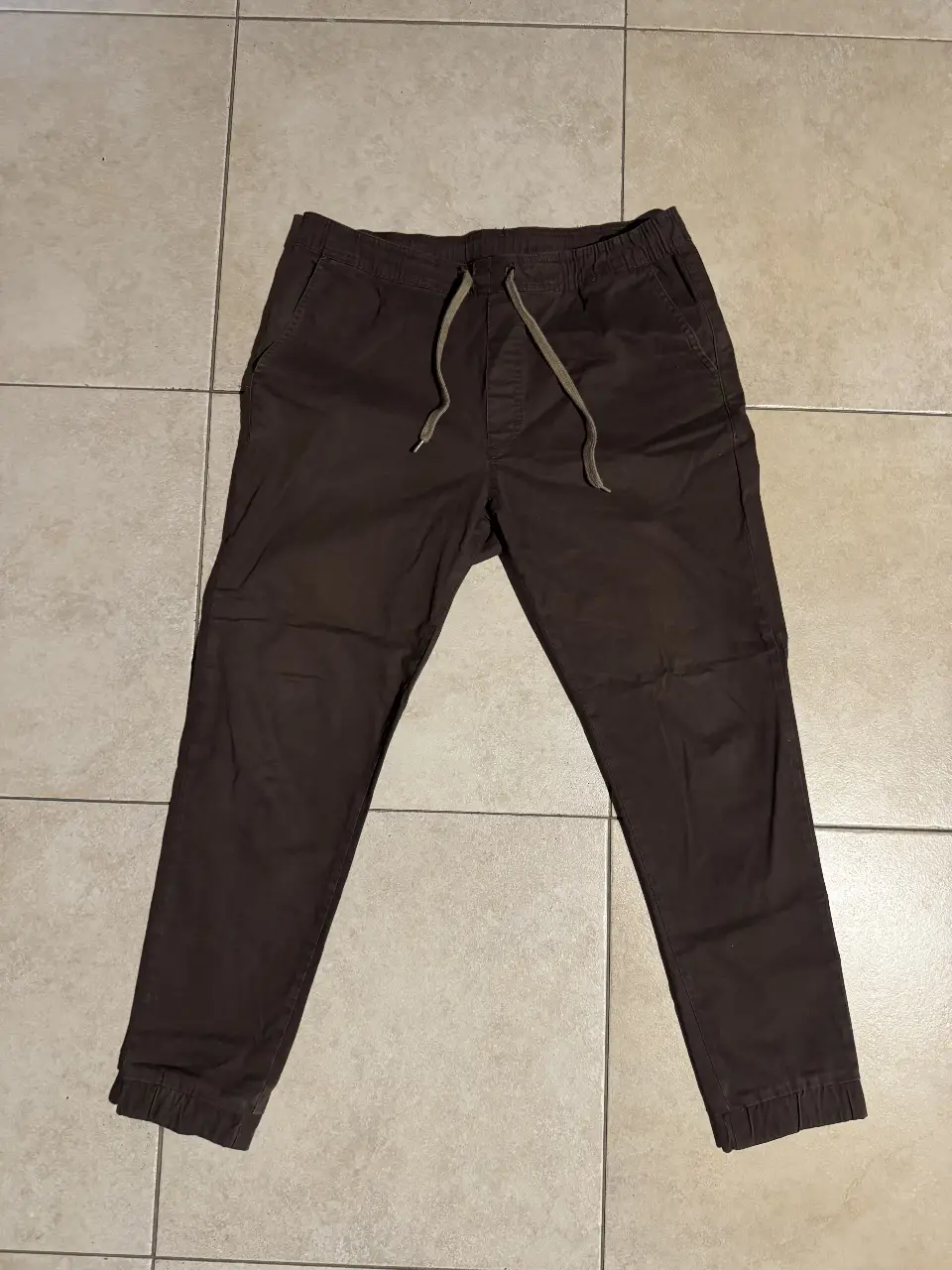 Pantalón chino marrón con cintura elastizada y cordón. Ideal para un look casual y cómodo.