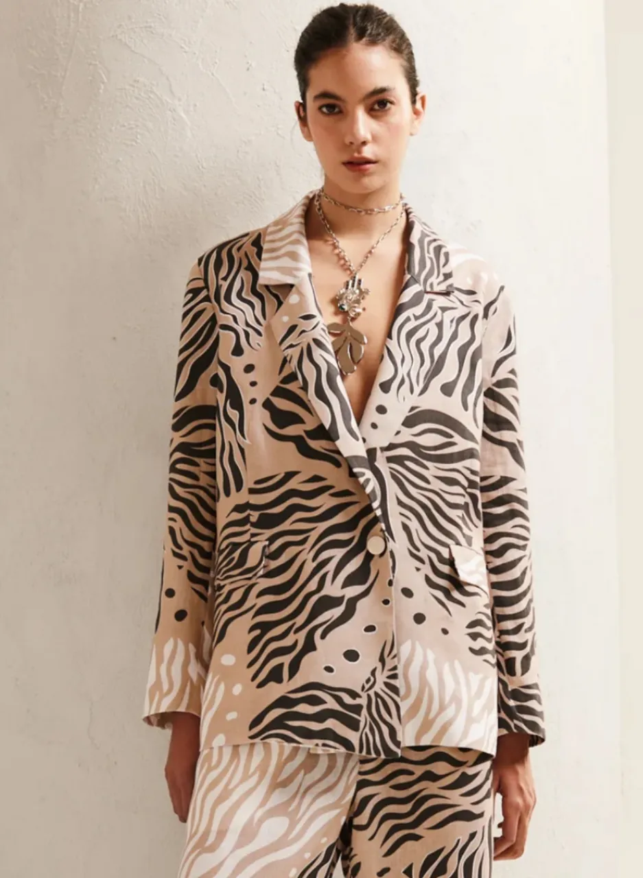 Blazer de mujer con estampado de cebra en tonos crudo y negro. Corte clásico con solapas y un botón. Ideal para un look moderno y audaz. 100 % lino con forro interno