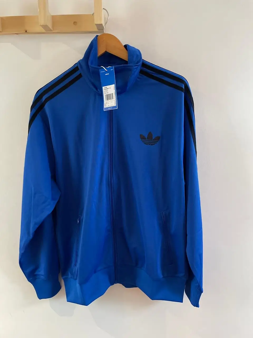 Conjunto deportivo Adidas azul con detalles en negro. Buzo con cierre y pantalón con las clásicas tres tiras. Ideal para un look deportivo y cómodo.