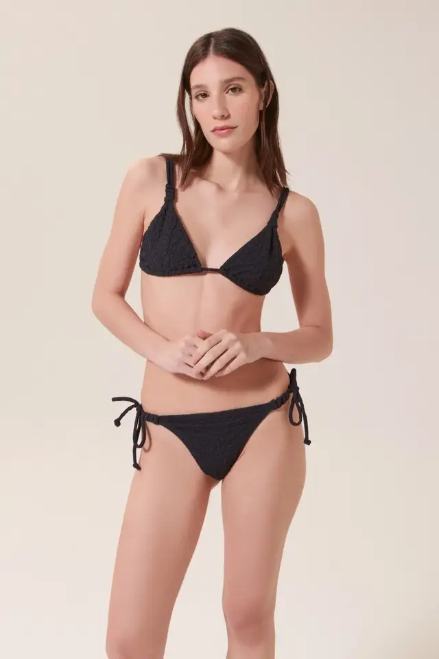 Conjunto de bikini negro con textura, ideal para la playa o pileta. Incluye corpiño triangular y bombacha con tiras ajustables.